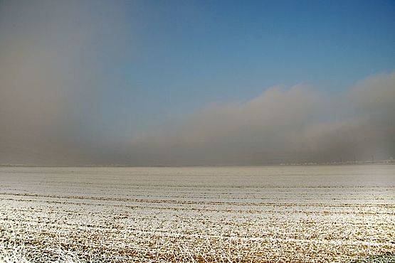 Foto zeigt mit Rauhreif bedeckte Felder vom Standpunkt Karlwaldstraße Blickrichtung West, am Horizont graue Altostratos-Bewölkung